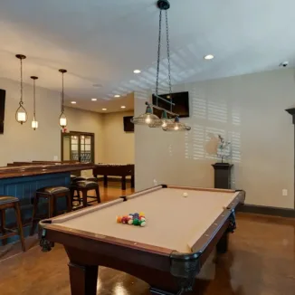 resident game room with billiards table and a bar