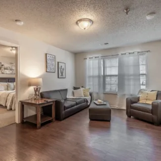 furnished living room with a door leading to furnished bedroom